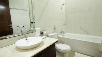 Un baño con lavamanos, inodoro y bañera.