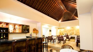 A restaurant with a bar area, wooden chairs, and tables. - Hotel Segara Agung (Denpasar)