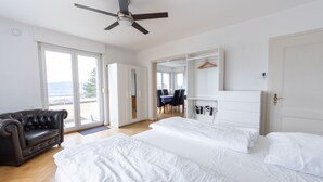 Un dormitorio con dos camas, un ventilador de techo, un armario y vistas al exterior.