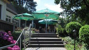 A set of outdoor stairs leading to a building with green umbrellas and outdoor seating. - Hotel Restaurant Rheinkrone Koblenz (Koblenz)