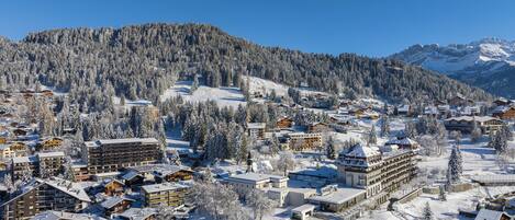 A snow-covered mountain town with wooden buildings and a ski resort.