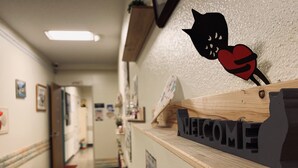Un comptoir d’accueil avec une pancarte « BIENVENUE » et une décoration représentant un chat noir.