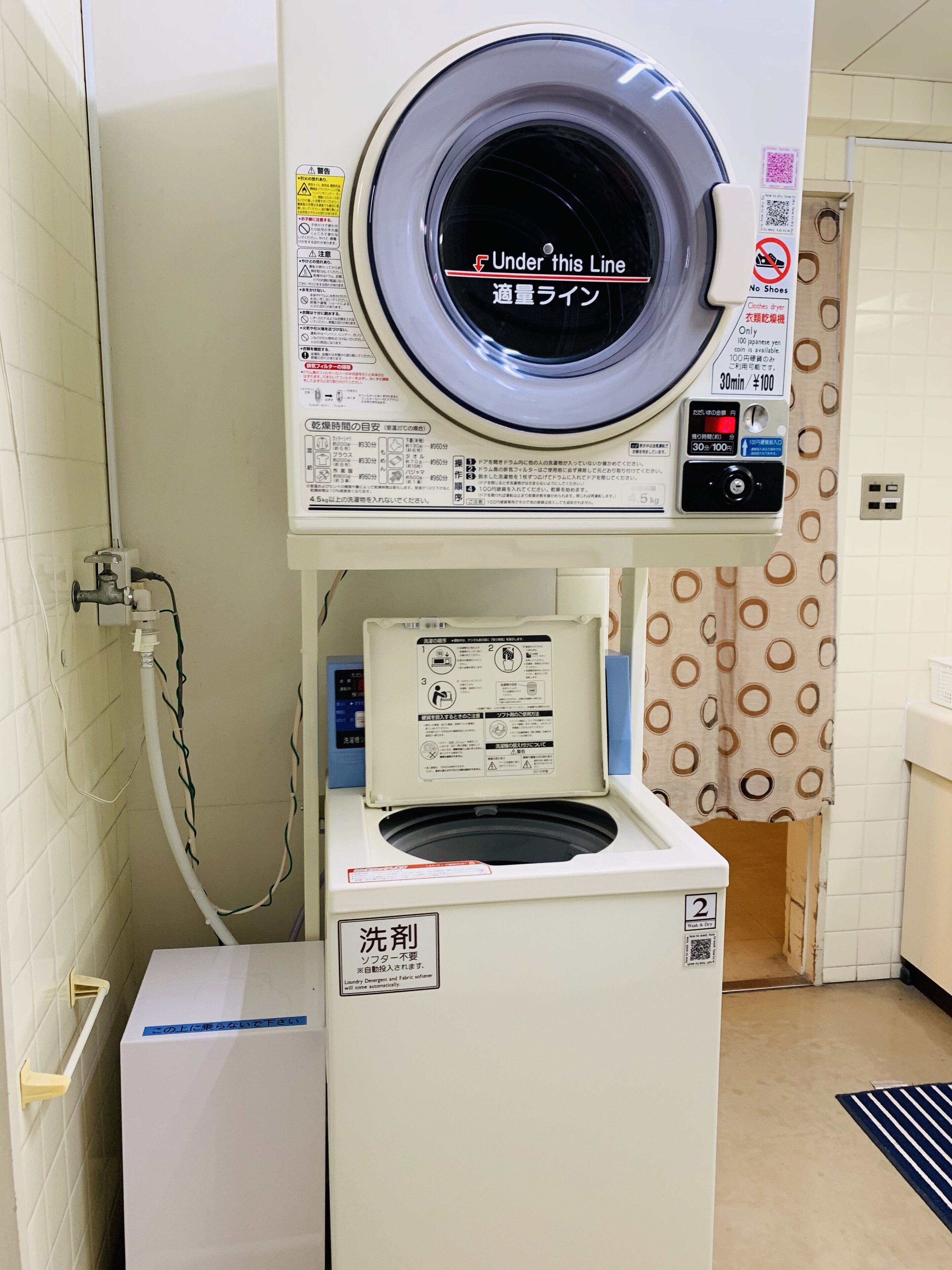 A laundry machine with a front-loading design, a control panel, and a label indicating it is for washing.