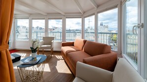 A modern living room with a sofa, a chair, a small table, and a potted plant. - Skyflats Vienna Belle View (Vienna)
