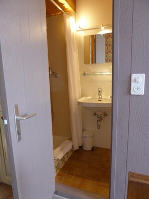 A small bathroom with a shower, sink, and toilet. - Au Vieux Manoir (Monthey)
