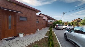 A residential street with houses, a driveway, and parked cars. - Villa Rubčić Rooms & Pansion (Rakovica)