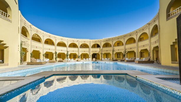Un área de piscina con varios niveles de arcos y una piscina central.