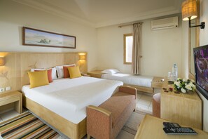 A hotel room with a large bed, a smaller bed, a desk with a chair, a TV, and a painting on the wall. - Ksar El Jerid Tozeur (Tozeur)