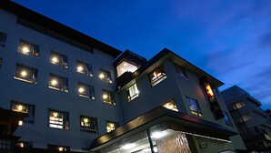 Un hotel de varios pisos con ventanas iluminadas y un cartel visible que indica que es un hotel.