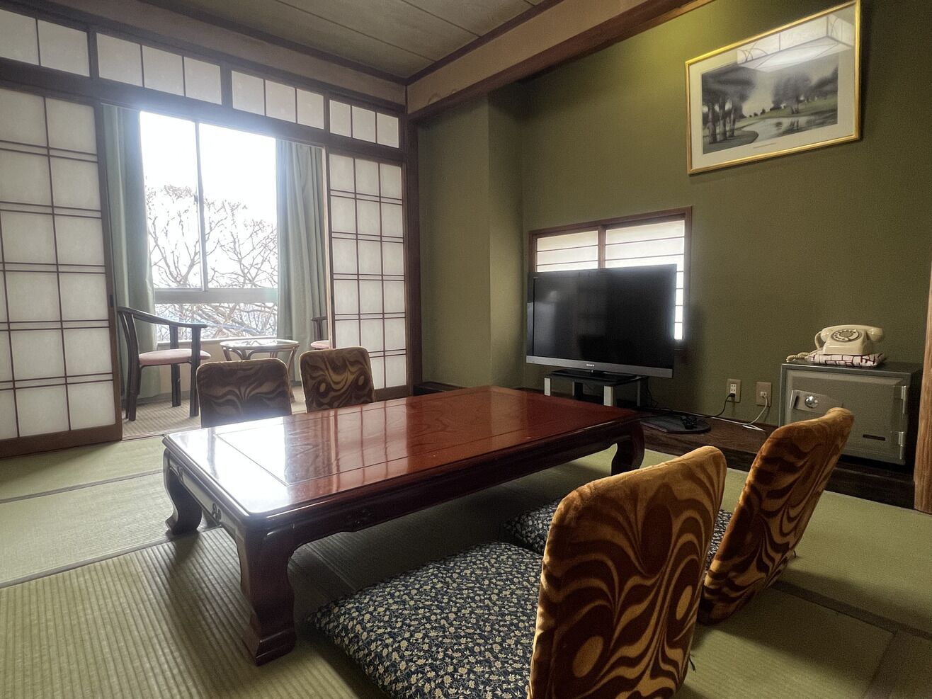 A traditional Japanese-style room with tatami flooring, a low table, and shoji screens.