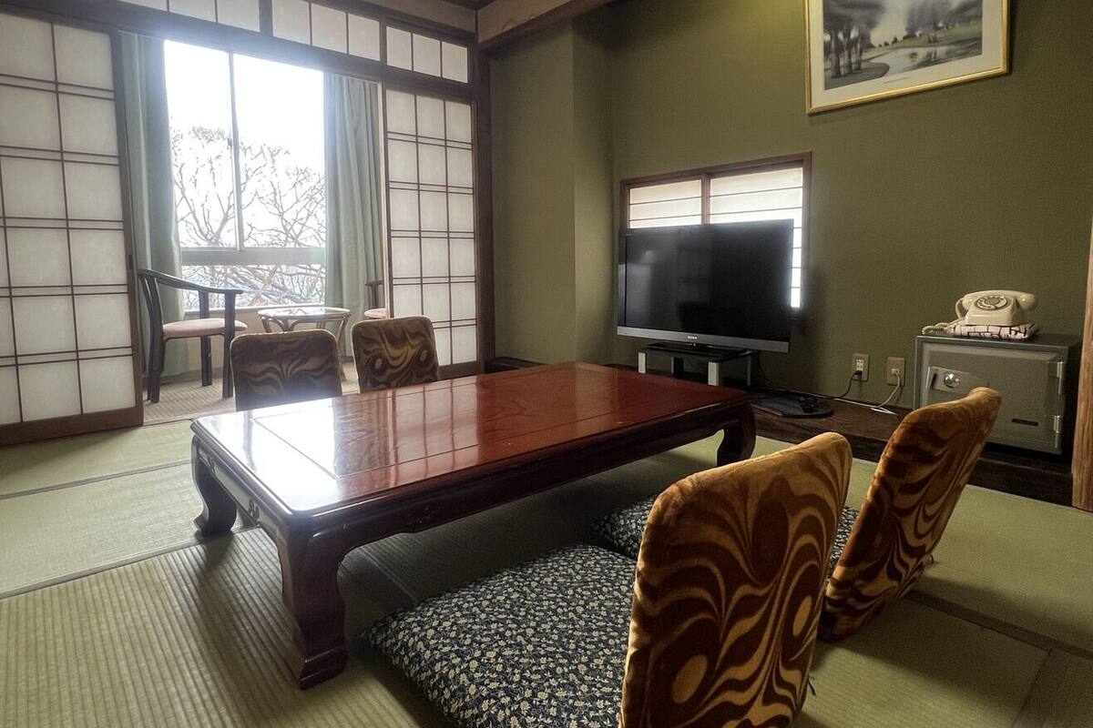 Um quarto em estilo japonês tradicional, com tatames, uma mesa baixa e portas shoji.