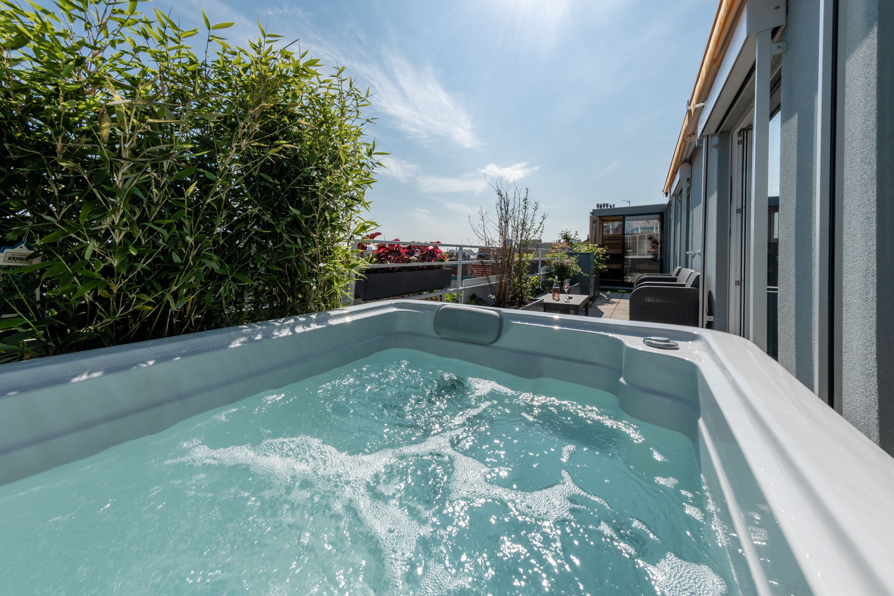 Ein Whirlpool auf dem Dach mit freiem Blick auf den Himmel und die umliegende Bepflanzung.