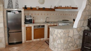 A kitchen with a built-in refrigerator, a dishwasher, a stove, and a sink. - Villa Mara (Slivno)