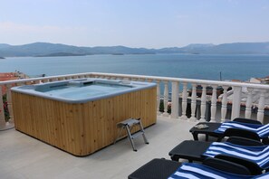 A wooden hot tub on a balcony with a view of the sea and mountains. - Villa Mara (Slivno)