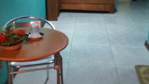 Una habitación con cama, una mesa con sillas y una planta en maceta.