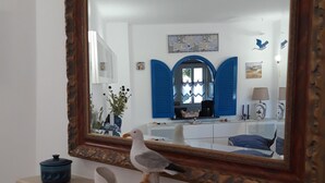 A room with a fireplace, a mirror, and decorative items including a seagull sculpture and a blue pot. - Sun terrace with beautiful sea views, 4 beautiful beaches, quiet location (Ferragudo)