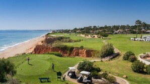 A golf course with a beach view, a sandy shoreline, and a clear sky. - Sun terrace with beautiful sea views, 4 beautiful beaches, quiet location (Ferragudo)