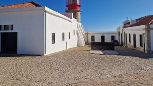A building with a red lighthouse, white walls, and a cobblestone courtyard. - Sun terrace with beautiful sea views, 4 beautiful beaches, quiet location (Ferragudo)