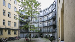A courtyard with a tree, bicycles, and a building with balconies. - 2ndhomes Kluuvi Studios (Helsinki)