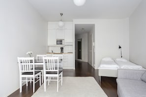 Un ambiente moderno e minimalista con zona pranzo, angolo cottura e un'area separata per dormire.