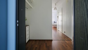 A narrow hallway with wooden flooring, white walls, and a ceiling light. - 2ndhomes Kluuvi Studios (Helsinki)