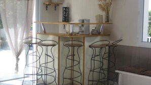 Een moderne keuken met een houten aanrecht, vier barkrukken en een raam met uitzicht.
