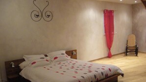 Een slaapkamer met een houten bed, een stoel en een rood gordijn.
