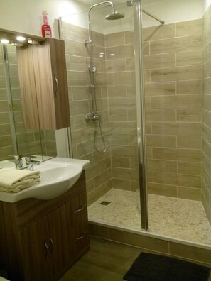 Vierpersoonskamer | Badkamer | Een douche, handdoeken, zeep, toiletpapier