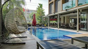 Een buitenzwembad, parasols voor strand/zwembad