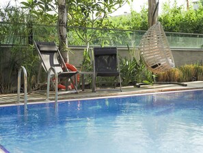 室外游泳池，池畔遮阳伞，日光浴躺椅