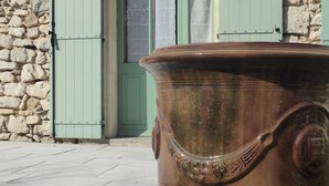 Un edificio de piedra con una maceta de terracota grande en la entrada.