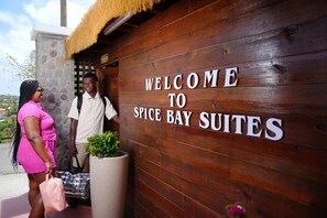 A wooden wall with the text "WELCOME TO SPICE BAY SUITES".