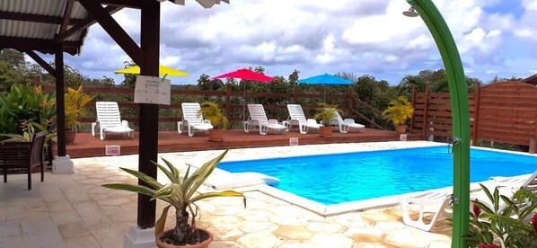 حمّام سباحة خارجي، مظلات على حمّام السباحة، مقاعد للتشمس