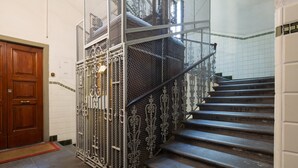 A staircase with ornate metal railings and a wooden door. - Elegant and comfortable apartment near the Duomo. The perfect location. (Firenze)