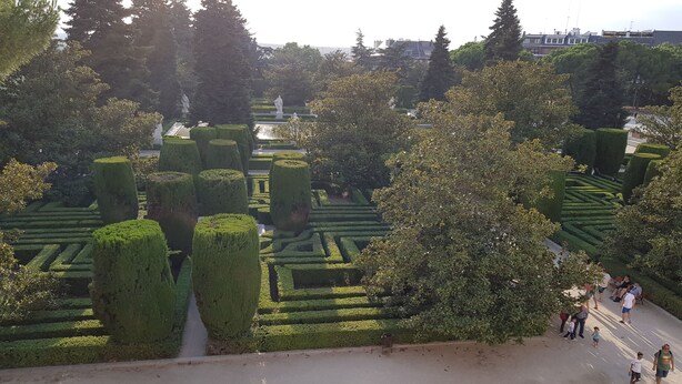 A formal garden with neatly trimmed hedges and statues. - Hostal Loyola - Hostel (Madrid)