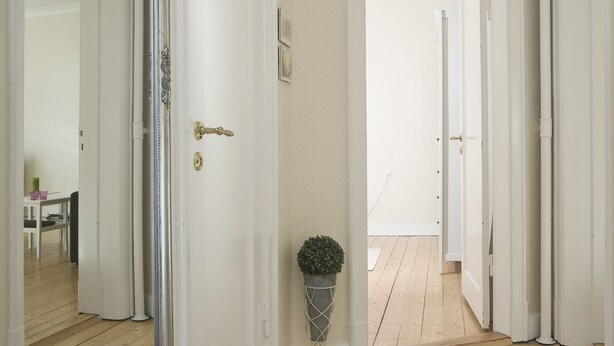 A hallway with wooden flooring, white doors, and a large mirror. - Aalborg City apartments (Aalborg)