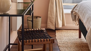 A bedroom with a large window, a plant, a framed artwork, and a bedside table. - Designer City Centre Apartment (Coventry)