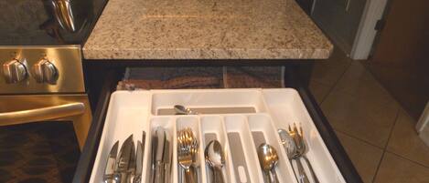 A kitchen drawer with utensils and a toaster.