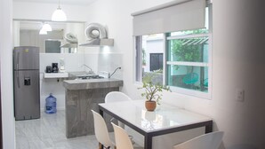 Una cucina moderna con isola centrale, elettrodomestici in acciaio inossidabile e zona pranzo con tavolo e sedie.