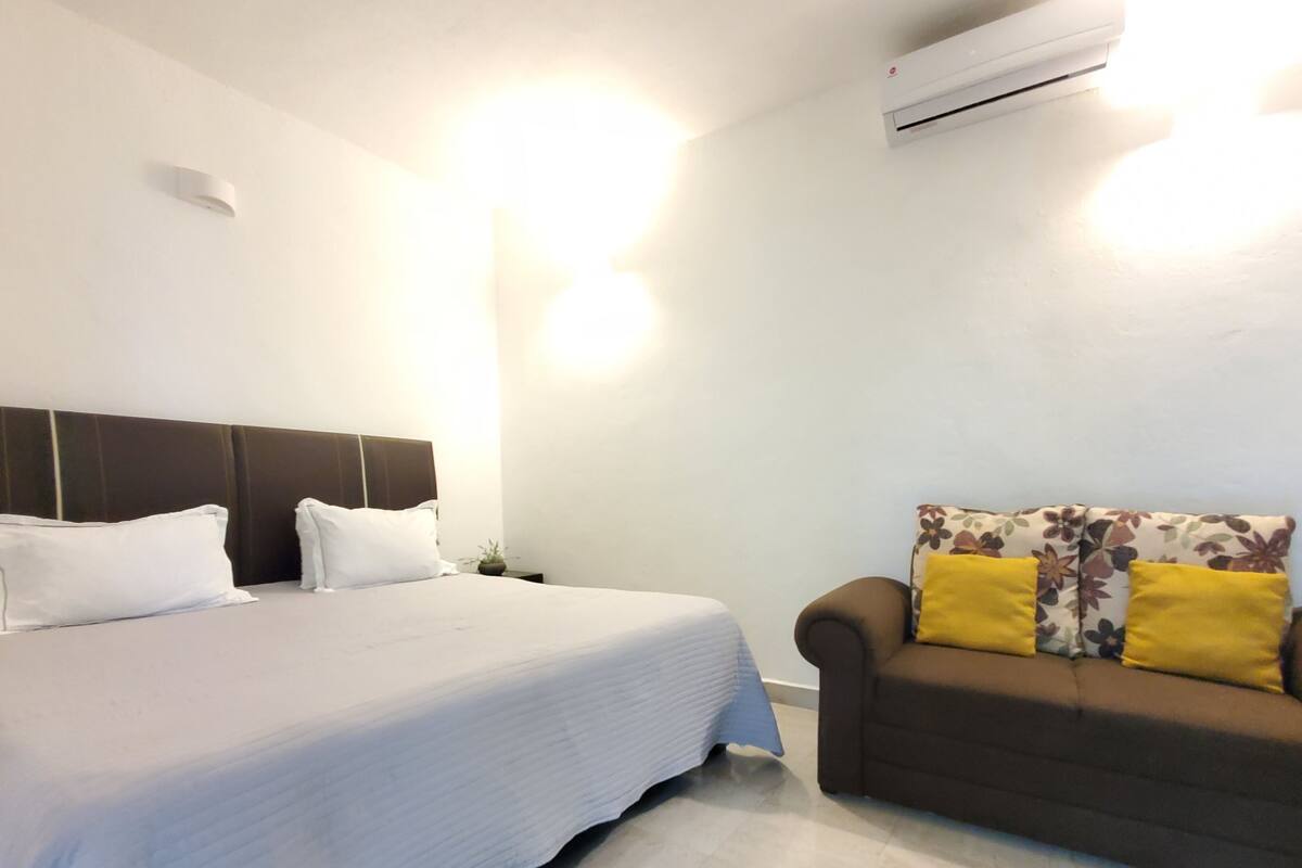 Ein Hotelzimmer mit Bett, Sofa und Klimaanlage.