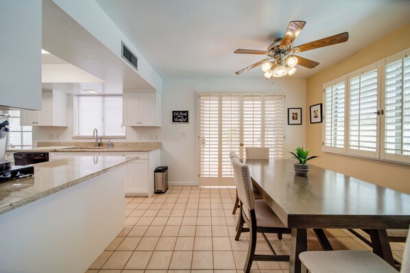 Enjoy family meals in this kitchen with a large island, sink, and dining area with a table and chairs.