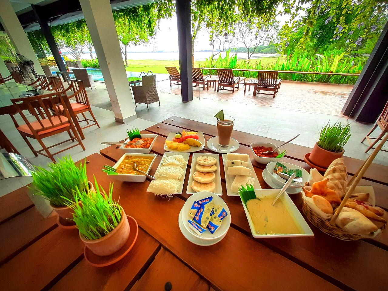 Una mesa de comedor con varios platos y vistas a un paisaje verde exuberante.