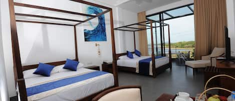 A hotel room with four wooden four-poster beds, a dining table with breakfast items, and a view of the outdoors.