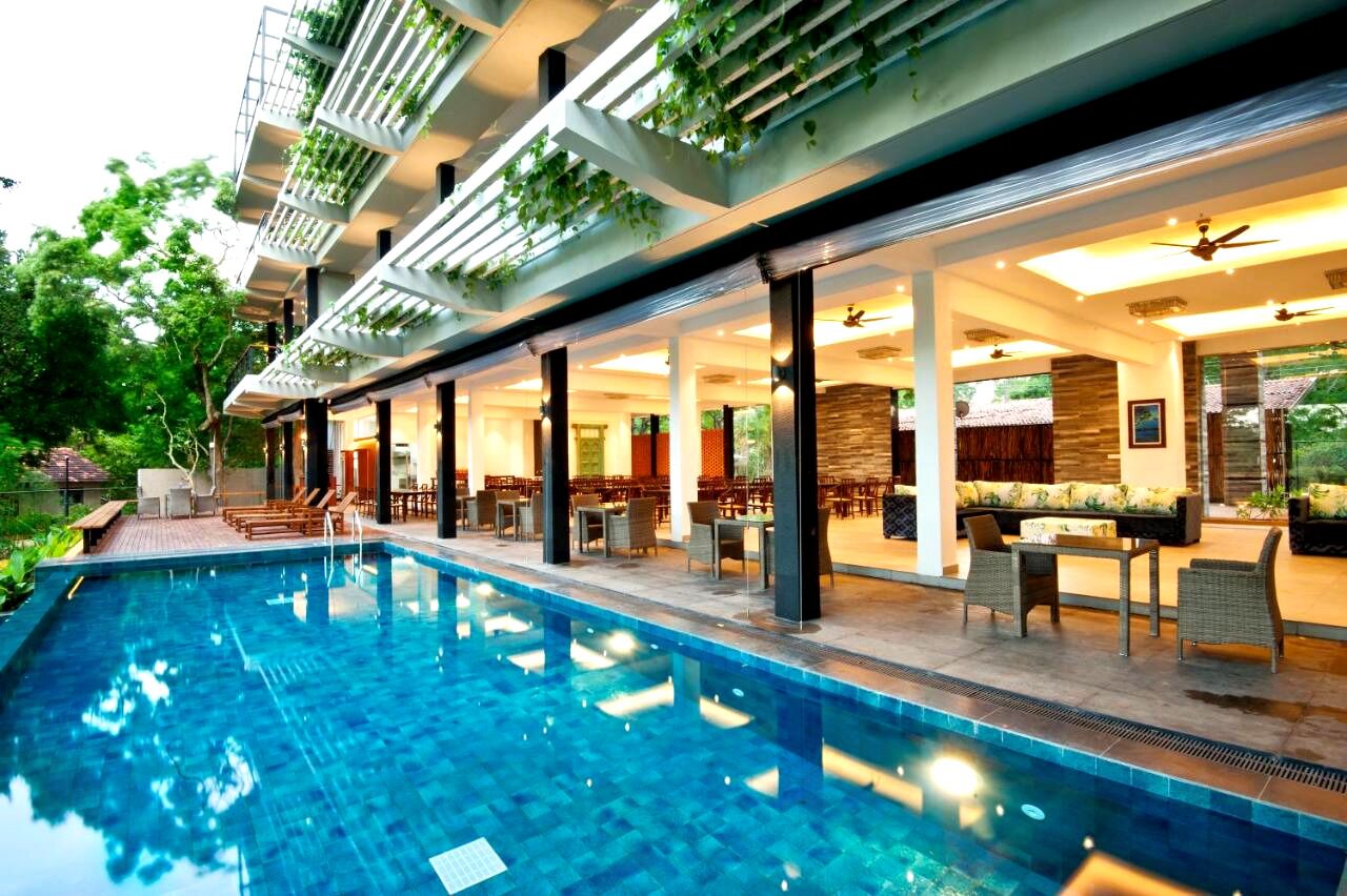 Una piscina al aire libre, sillones reclinables de piscina