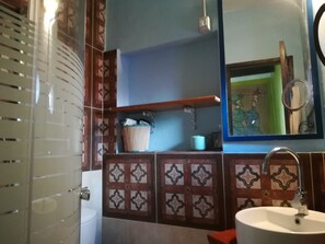 A bathroom with a white sink, a mirror, and a shelf with toiletries. - I Miti Vivienda Vacacional (Guia de Isora)