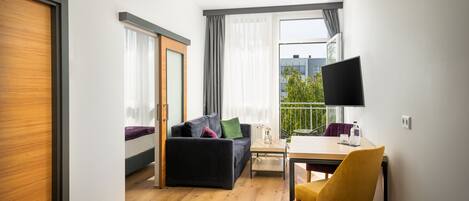 Una habitación moderna con sofá, una mesa de comedor y televisión.