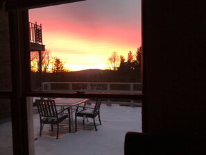 A view from a window overlooking a snowy patio with a table and chairs, and a balcony railing. - Entire Guest Suite in Haus Edelweiss on the Blue Ridge Parkway (Marion)