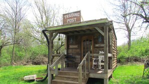 A wooden post with a sign reading "TRADING POST" and a small porch with steps leading up to a door. - Unplug at cabin for 2 (Polk)