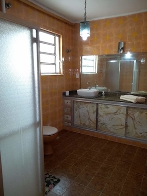 A bathroom with a toilet, sink, and mirror.