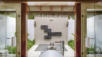 Une salle de bain moderne avec une paroi de verre, une baignoire blanche et un design minimaliste.